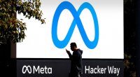 Homem passando em frente a letreiro com o logo da Meta, nova marca da empresa do Facebook