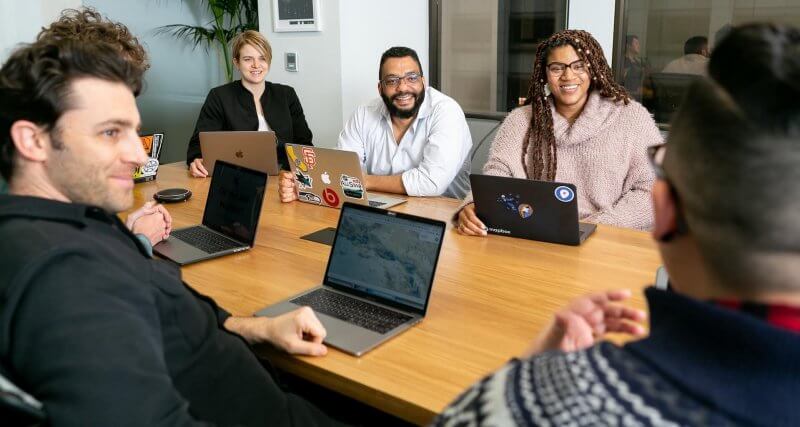 Líder fazendo a gestão de equipe em uma reunião presencial