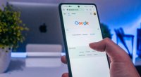 Homem no celular acessando o Google, que vai testar o protocolo IndexNow