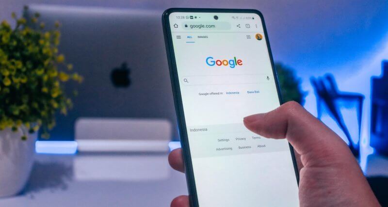 Homem no celular acessando o Google, que vai testar o protocolo IndexNow