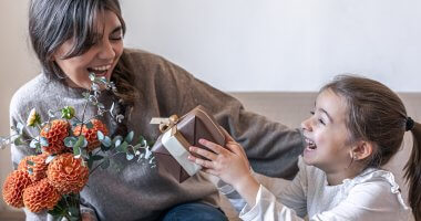 Filha entregando presente comprado em uma campanha de Dia das Mães