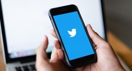 Homem usando o app do Twitter no celular, que deve englobar a funcionalidade do Twitter Flock em um futuro próximo