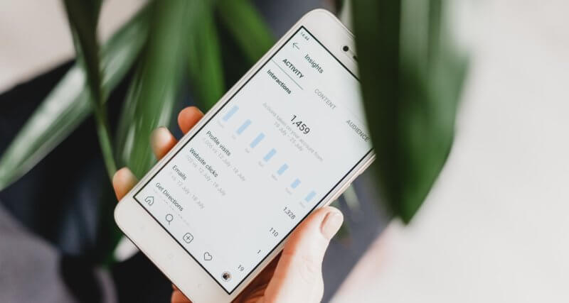 Celular mostrando métricas de alcance de uma conta do Instagram na tela